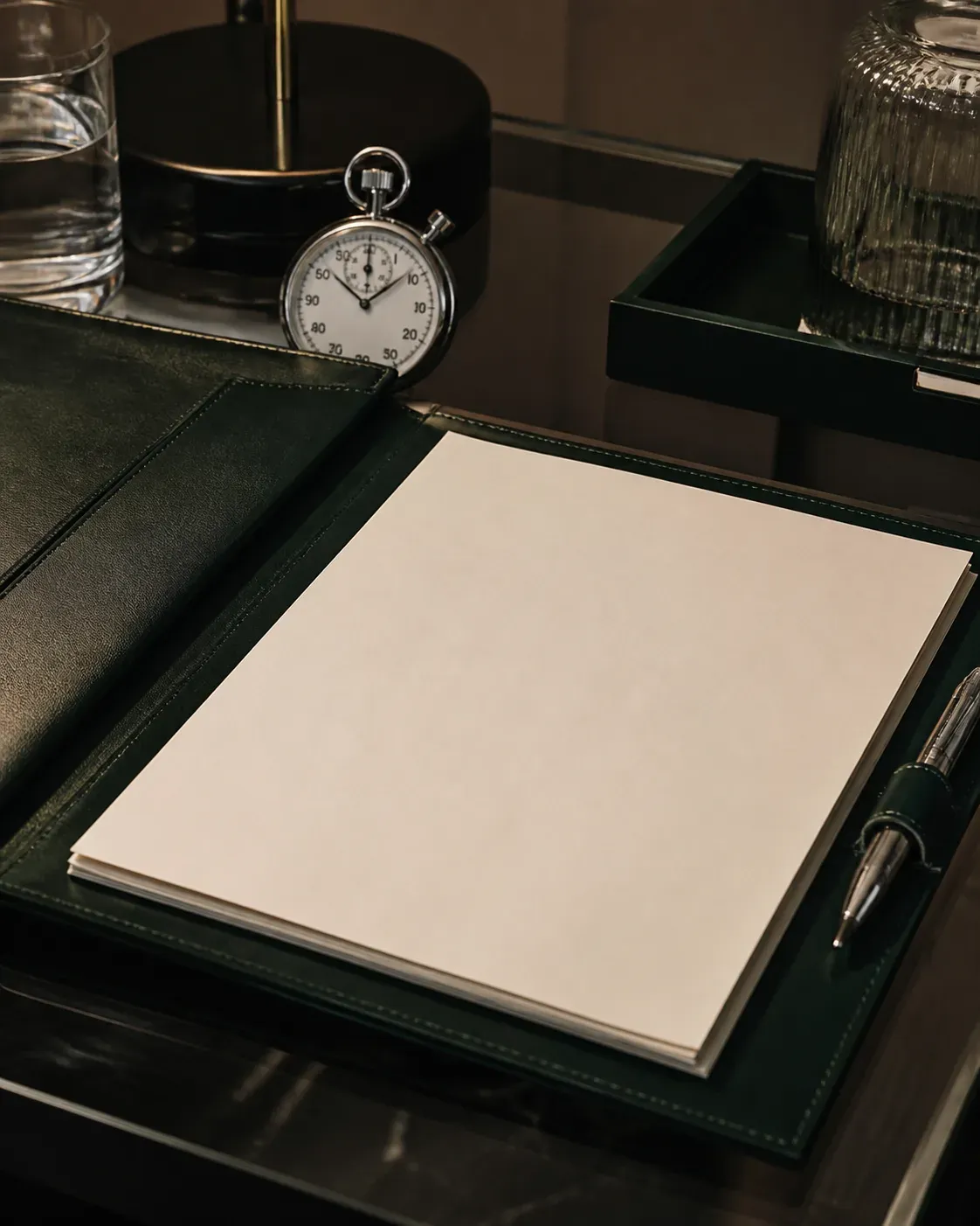 Contract file, stopwatch and documents on a deep green table